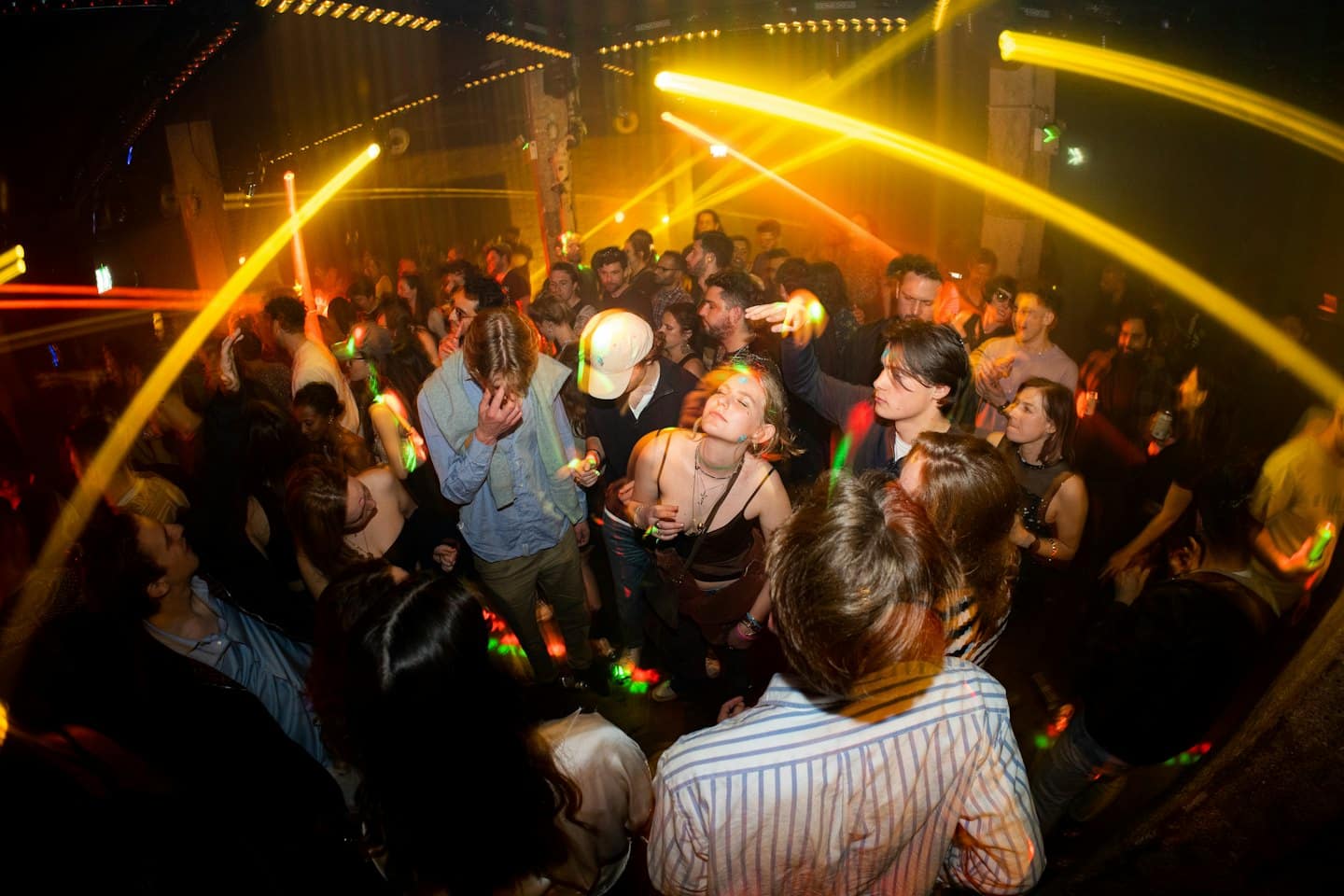 Junge Erwachsene tanzen und feiern in einem lebhaften Nachtclub.